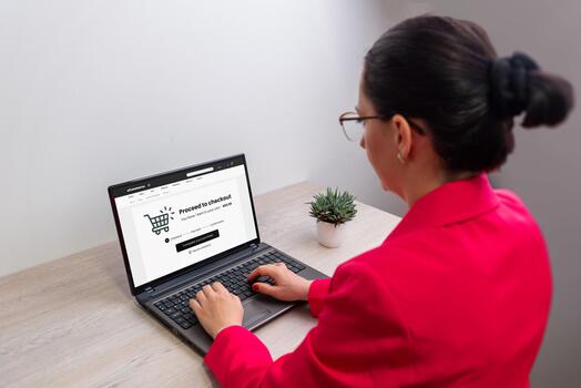 Woman using laptop for online checkout process, e-commerce payment screen on display, concept of digital shopping, internet transaction, and secure purchase photo