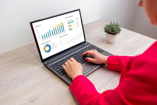 Woman working on laptop analyzing financial dashboard with charts and graphs, concept of data analysis, performance tracking, and business intelligence photo