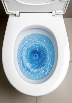 Clean Toilet Bowl with Swirling Blue Water in Background View photo
