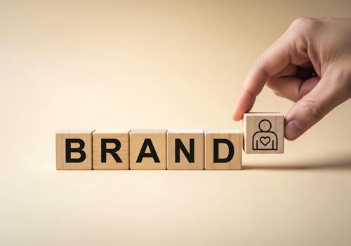 Hand Placing Icon Block in Word Brand on Neutral Background photo