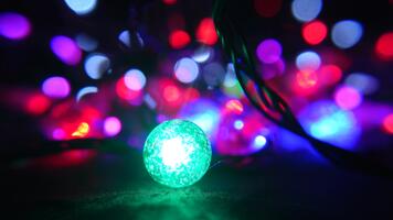 A close up of glowing string lights creating a dreamy bokeh backdrop, featuring a red and green glass ball. video