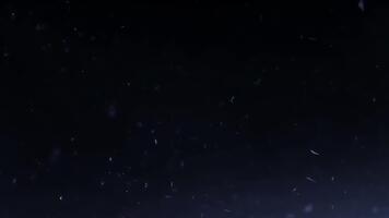 klein wit deeltjes langzaam vlotter naar beneden tegen een donker achtergrond, teder sneeuwval effect video