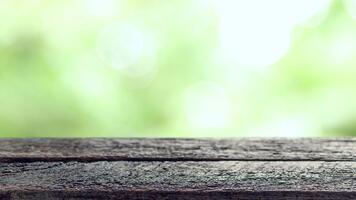 vecchio di legno tavolo con morbido luce del sole e naturale bokeh sfondo. Perfetto come un' fondale per Prodotto Schermo, presentazioni, o rilassante natura temi. video