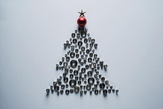 Christmas tree silhouette made from metallic nuts and bolts with red bauble accent, minimalist workshop theme photo