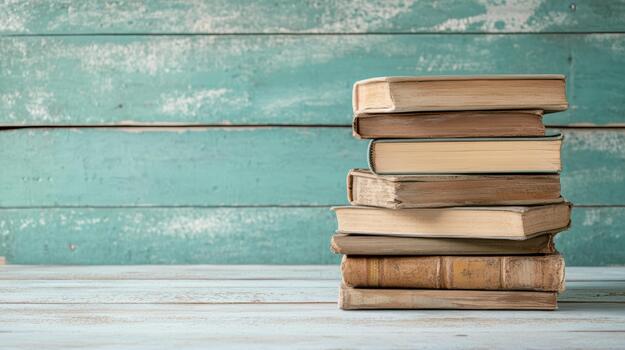Old books on wooden table with turquoise wall background photo
