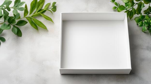 Blank white box on a table with green leaves photo