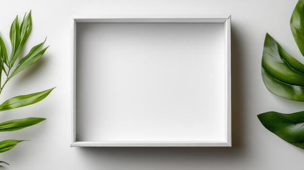 Empty white box with green leaves on a white surface photo