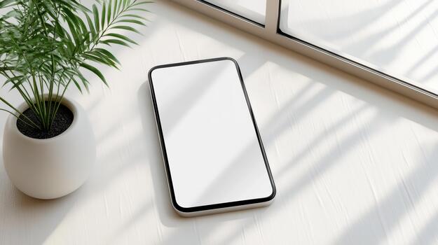 Smartphone and plant on a white table with a window photo