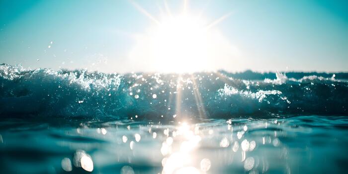 Sunlight sparkles on a cresting ocean wave creating a refreshing and vibrant scene photo