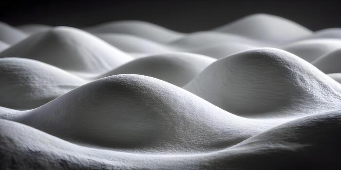 Soft white textured mounds create an abstract pattern against a dark background photo