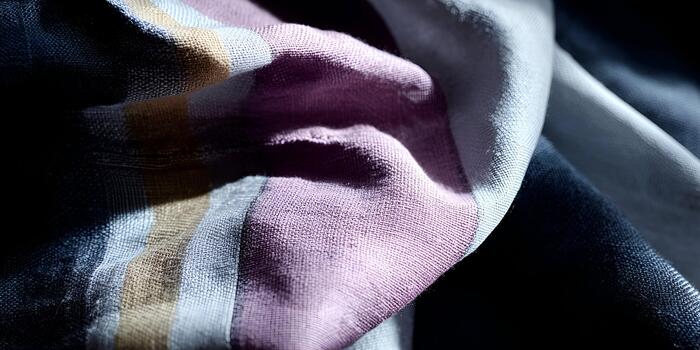 A close up view of a textile featuring colorful striped fabric with visible texture and folds photo