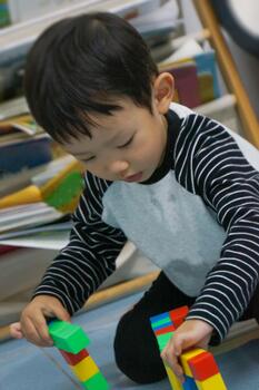 A focused child engrossed in playing with colorful blocks, a scene of creative building and developmental activity photo