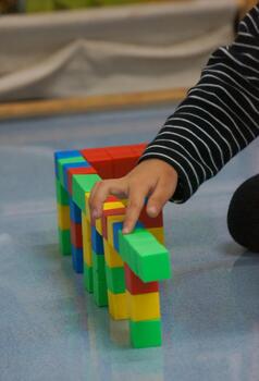 A child's hands building a structure using colorful blocks. This scene highlights creativity, learning, and play with colorful blocks. photo