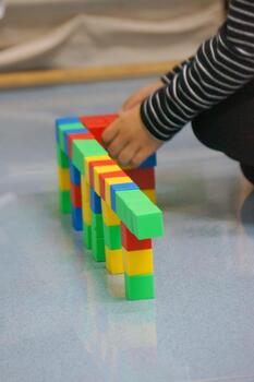 Little hands building a structure using colorful blocks. This scene highlights creativity, learning, and play with colorful blocks. photo