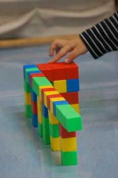 A toddler's hands building a structure using colorful blocks. This scene highlights creativity, learning, and play with colorful blocks. photo
