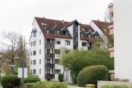 Residential building with modern architecture surrounded by greenery in a suburban setting during overcast weather photo