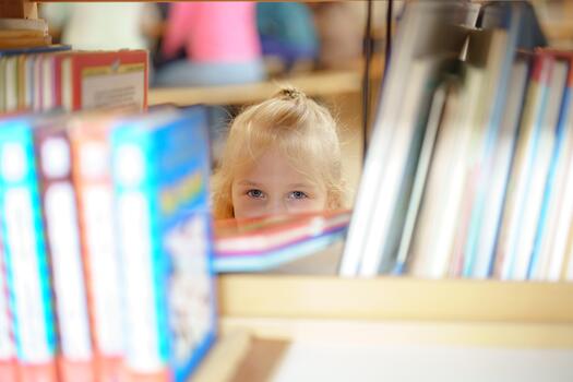 Child peeking from behind library shelves during a reading session in a vibrant, busy environment photo