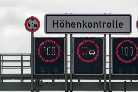 Traffic control signs display height limit and speed restrictions on a highway in Germany during daytime photo