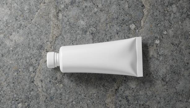 Simple White Tube on a Textured Stone Surface, Perfect for Showcasing Product Details or Design Elements photo