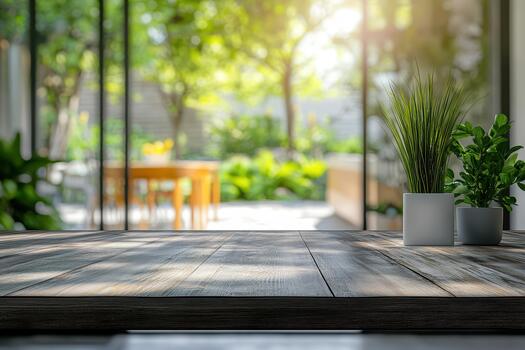 An empty table with plants in front of a glass door photo