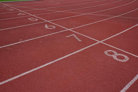 Overhead Shot of Textured Synthetic Red Running Track Lanes and Numbers photo