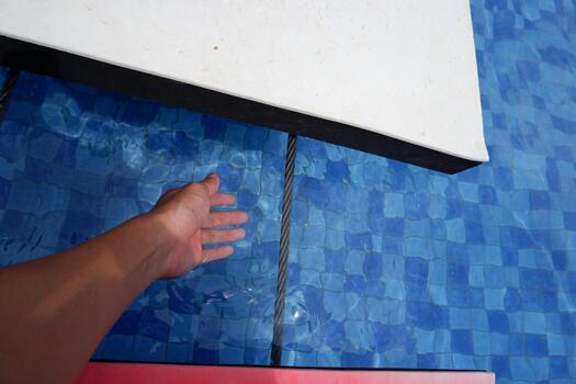 Close Up Contemporary Minimalist Floating Platform with Hand Reaching Over Pool photo