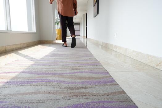 moderno resumen horizontal estampado alfombra en un brillantemente iluminado hotel pasillo foto