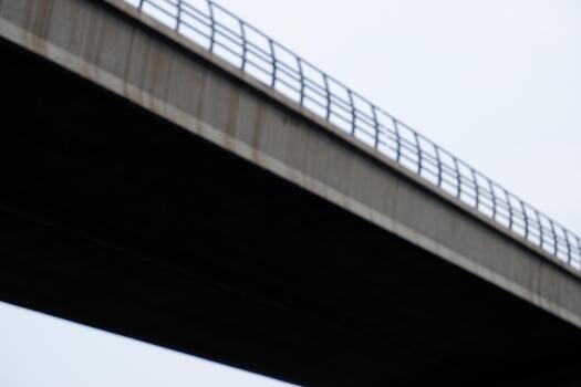 Abstract Concrete Bridge Underside Structure with Railing and Overcast Sky photo