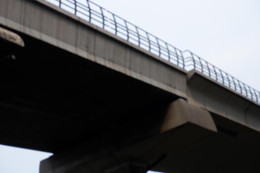 Low Angle Blurred Architectural Concrete Bridge Underside with Metal Railing photo