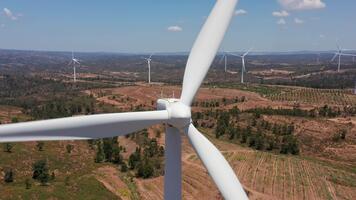 perspectiva destacando turbina superficie caracteristicas y rodeando paisaje, magnificado ver de turbina góndola superficie texturas con distante renovable energía formación en luz de sol video