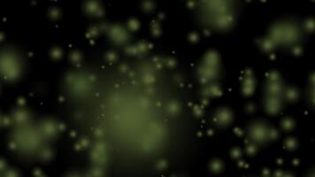 Abstract black background with glowing green bokeh circles and blurry light particles creating a magical mysterious design video
