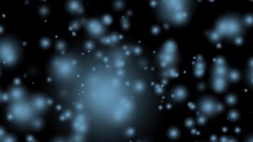 Abstract light blue particles bokeh effect on a dark background creating a shimmering ethereal glow video