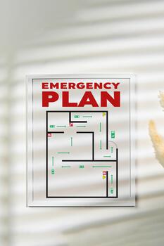 Emergency plan layout displayed on a wall with sunlight shadows creating patterns photo