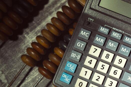 Calculating with tools on a wooden table in a workspace setting photo