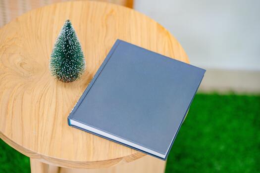Top view of blank book with mini christmas tree on wood table. Mockup Christmas background with blank page book for text. Flat lay with copy space concept. photo