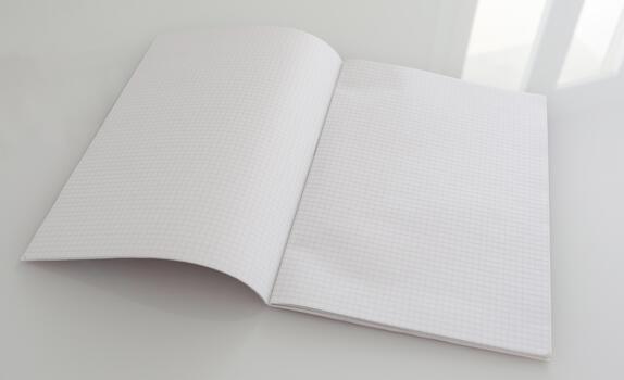 Open blank grid paper notebook on clean table photo