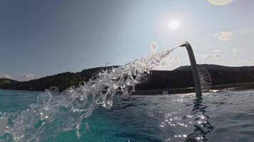 Water flows from a fountain into an outdoor pool, sparkling in the sunlight and creating gentle ripples across the calm surface. video