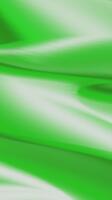 grön lutning bakgrund en lugn blandning av ljus och skugga i en slät, slät grön flytande Vinka animering med glansig slingor och elegant strömmande rörelse, looping abstrakt bakgrund video