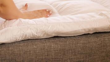 un' persona Aggiunge un' materasso cappello a cilindro per un' divano nel loro vivente camera. Questo azione è fatto per rendere il divano Di Più confortevole per dormendo. il ambientazione Spettacoli un' semplice casa impostare video