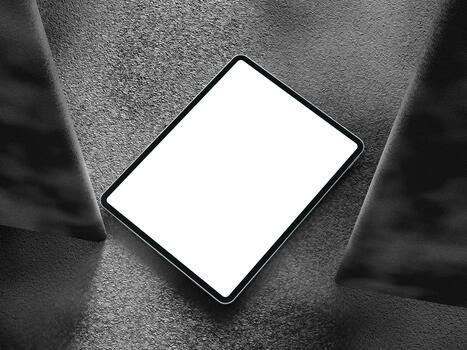 Clean tablet screen displayed on a dark textured background with sharp lighting effects. photo