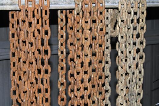 Frontal Picture OF Different Colored Rusted Chains Hanging photo