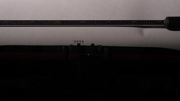 Vintage ▾ macchina da scrivere digitando ripetuto domanda votazione su bianca carta, evocando dubbio, mistero e il ricerca per risposte nel un' noir ispirato, retrò scrittura scena video