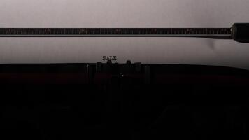 årgång skrivmaskin skriver de ord försäljning på en ark av vit papper, skapande en nostalgisk känsla och representerar företag, handel, marknadsföring, och retro kommunikation begrepp video