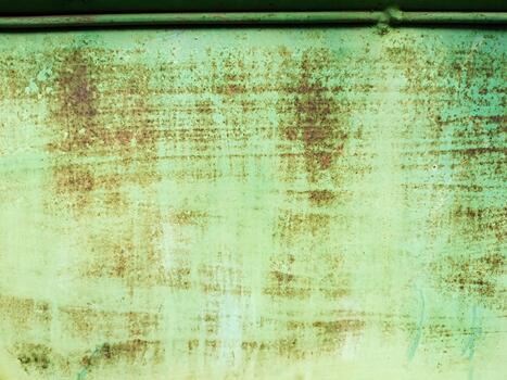 A Close Up Section of an Aged Green Metal Surface with Visible Rust Stains and a Faint Geometric Square Pattern. photo