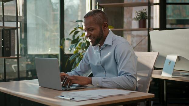 African American 40s business man typing laptop web service cyberspace adult businessman working online at office smiling mature male executive worker manager developer with computer data programming photo