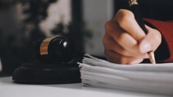 A judge's gavel is sitting on a desk with a stack of papers video