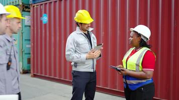 ingenjörer och förman samarbeta i ett industriell behållare gård, inspekterande lådor medan delning idéer handla om pågående projekt och lagarbete. deras utbyta slingor de betydelse av samarbete. video