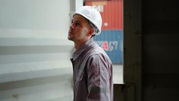 en ung caucasian förman öppnas en behållare låda i en logistisk lager, kontroll de frakt är prydlighet och organisation. de fokus är på säkra och effektiv frakt operationer video