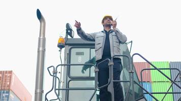 logistisch oder Ingenieur Mann reden auf Walkie-Talkie erklären Projekt mit Kollege auf Gabelstapler im Container Lagerhaus. inspizieren zum Qualität Kontrolle. Versand Lieferung und Export importieren video