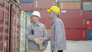 Two young engineers wearing safety uniforms approached and inspected logistics operations on a laptop at a container terminal, discussing workflow and safety enhancements for better efficiency video